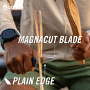 A close-up of a person using a Gerber FastballMagnacut blade to shave wood, with text overlays comparing the magnetic edge to the plain edge. The person is wearing a beige shirt and green shorts, and the Gerber logo is visible in the top left.